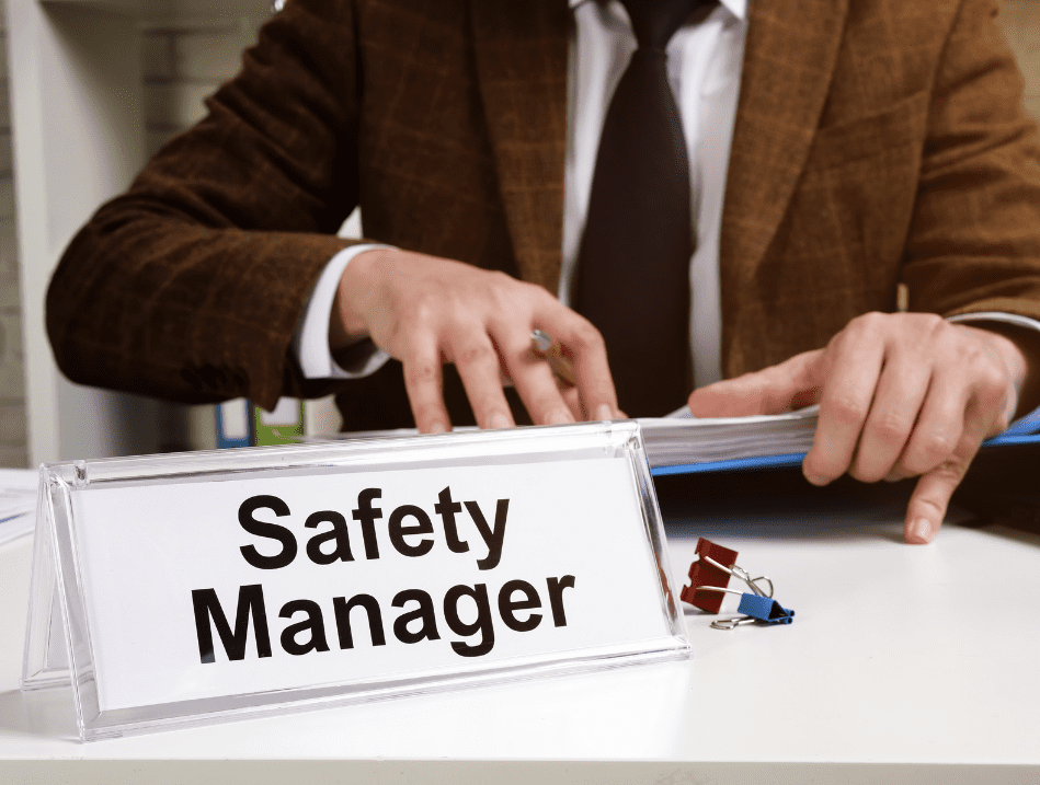 Safety Manager sitting at Desk looking at First aid and CPR OSHA Requirements for the workplace